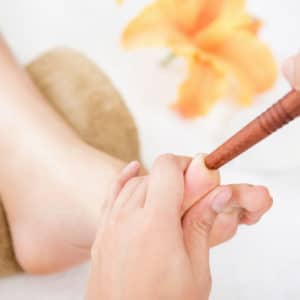 Massage des pieds thailandais avec un bâton de bois I Ô Pays des Sens